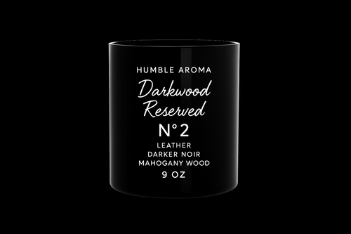 Black candle container with white text on a white background